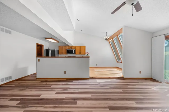 a view of a livingroom with wooden floor and stairs