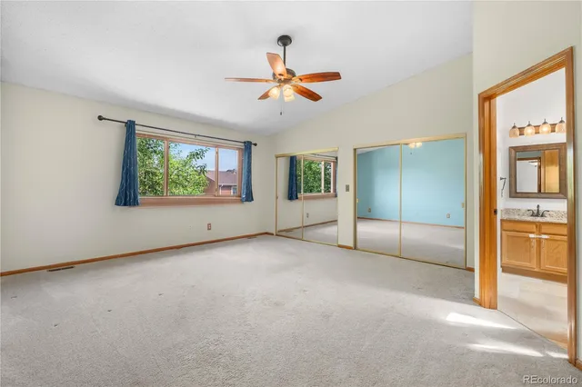 an empty room with fan and windows