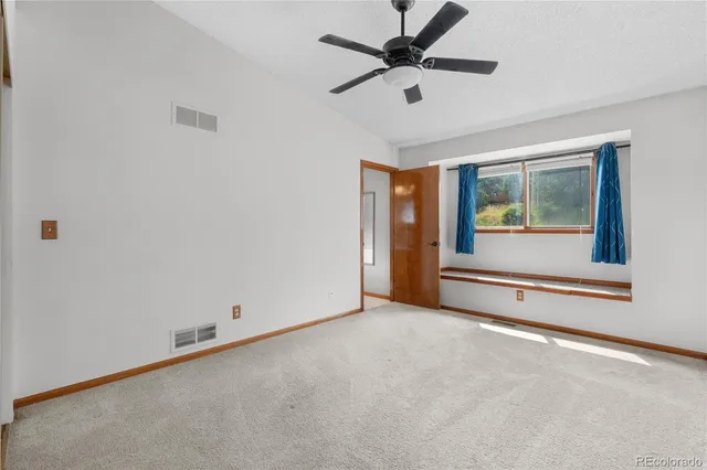 an empty room with closet and windows