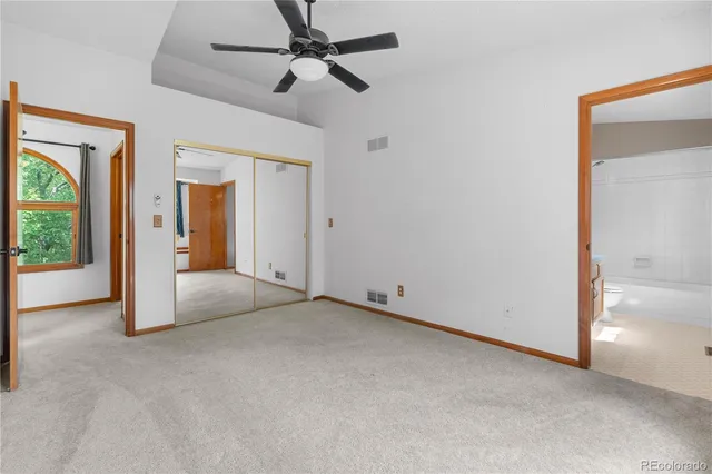 an empty room and a ceiling fan in a room next to a window