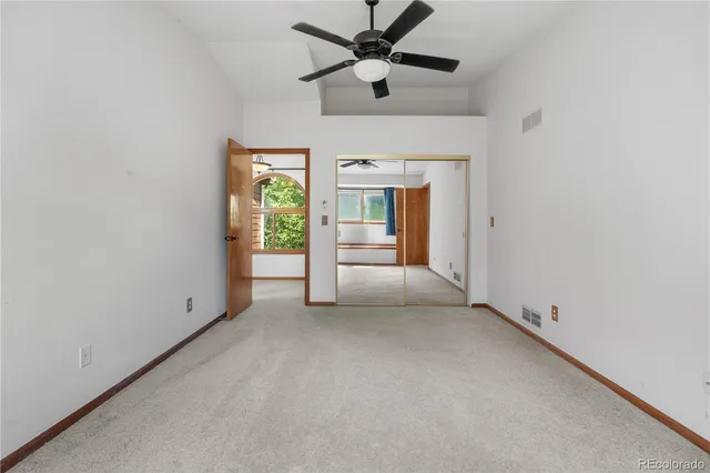 an empty room with a window and a ceiling fan