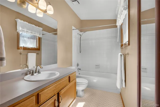 a bathroom with a granite countertop sink toilet a shower and a mirror