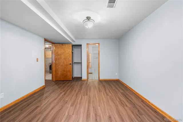 a view of an empty room with closet and a window