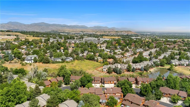 an aerial view of residential houses with outdoor space and trees