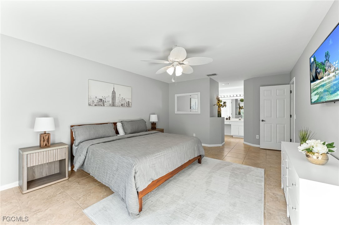 8468 Grove Road Fort Myers, FL 33967 - Photo 12 of 24 a spacious bedroom with a bed and a chandelier