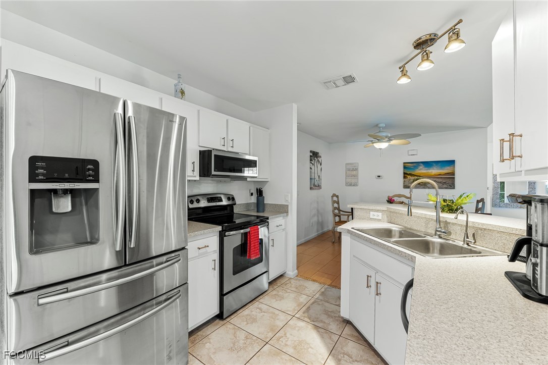 8468 Grove Road Fort Myers, FL 33967 - Photo 9 of 24 a kitchen that has a sink cabinets and stainless steel appliances