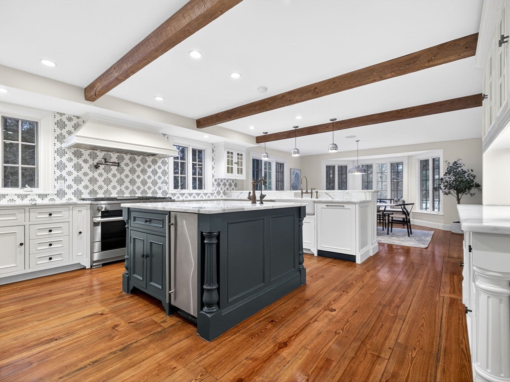 12 Winding River Circle Wellesley, MA 02482 - Photo 13 of 40 a kitchen with stainless steel appliances kitchen island granite countertop wooden floors and white cabinets
