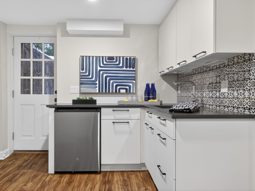 12 Winding River Circle Wellesley, MA 02482 - Photo 36 of 40 a kitchen with stainless steel appliances granite countertop a sink and dishwasher with wooden floor