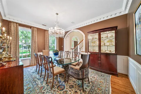 a dining room with furniture a chandelier and wooden floor