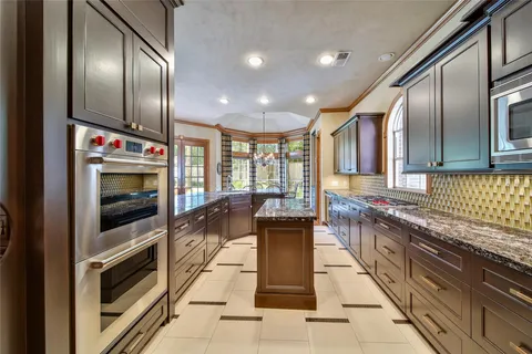 a kitchen with stainless steel appliances granite countertop a stove and a microwave