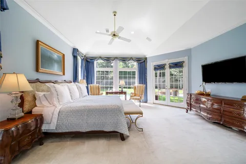 a spacious bedroom with a bed and large flat screen tv