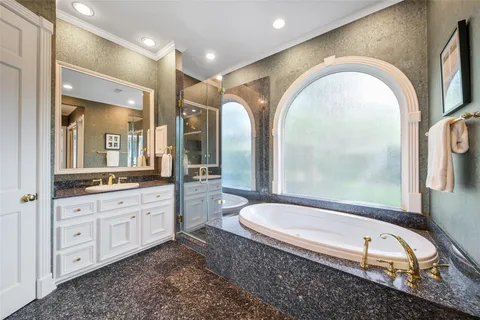 a spacious bathroom with a granite countertop tub a double vanity sink and a mirror