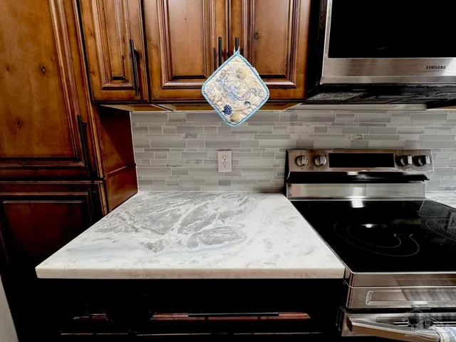 a kitchen with granite countertop cabinets a sink and a stove