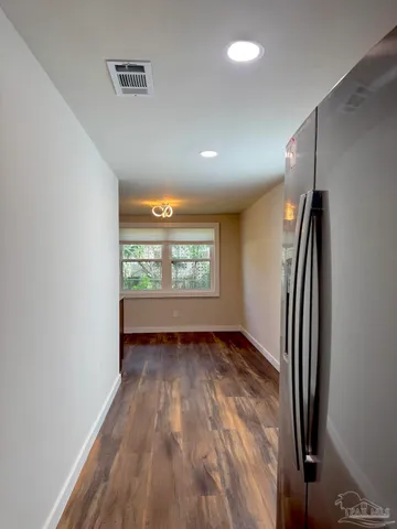 a kitchen with a wooden floor and cabinets