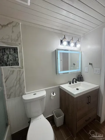 a white toilet sitting next to a shower