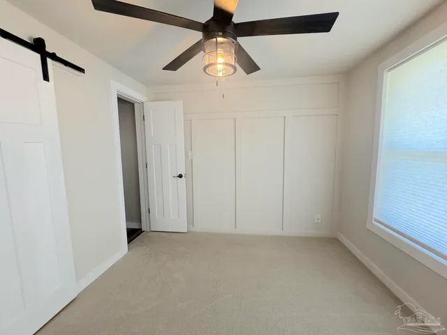 an empty room with a window and a fan