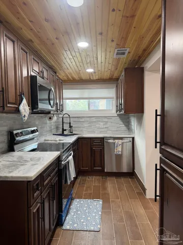a kitchen with stainless steel appliances granite countertop a sink stove and microwave