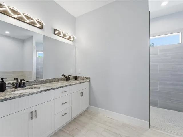 a bathroom with a double vanity sink and a mirror