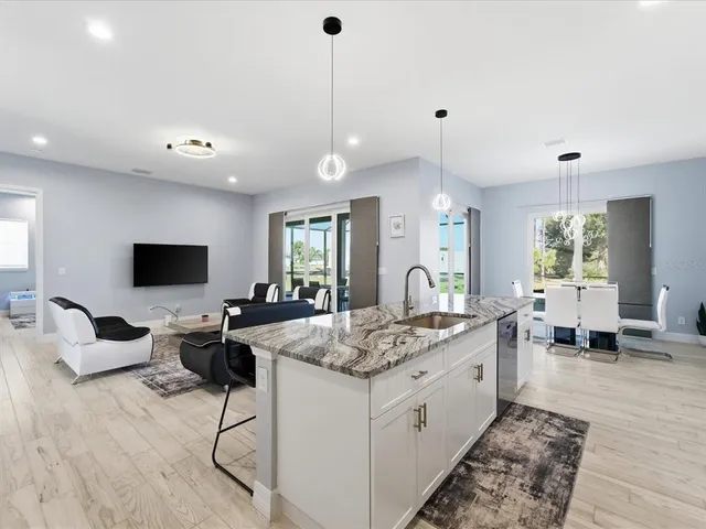 a living room with stainless steel appliances kitchen island granite countertop furniture and a flat screen tv