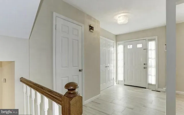 a view of a hallway to a room with wooden floor and stairs
