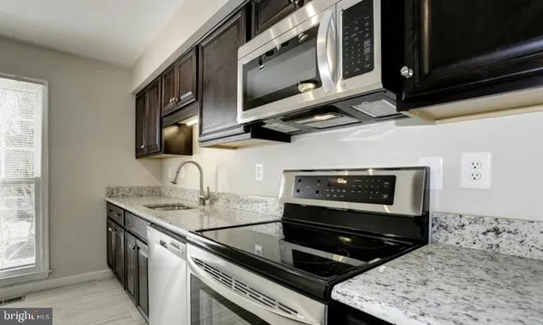 a kitchen with stainless steel appliances granite countertop a stove and a microwave