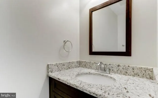 a bathroom with a granite countertop sink and a mirror