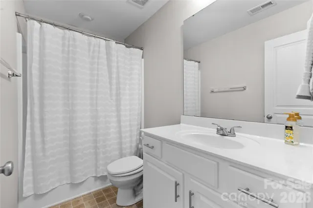 a bathroom with a sink a toilet and shower curtain