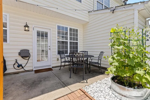 a view of a patio with table and chairs and potted plants