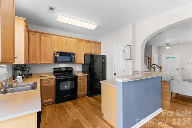 a kitchen with a sink a counter top space appliances and cabinets