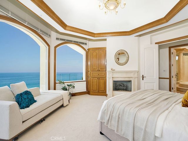 a spacious bedroom with bed and a chandelier