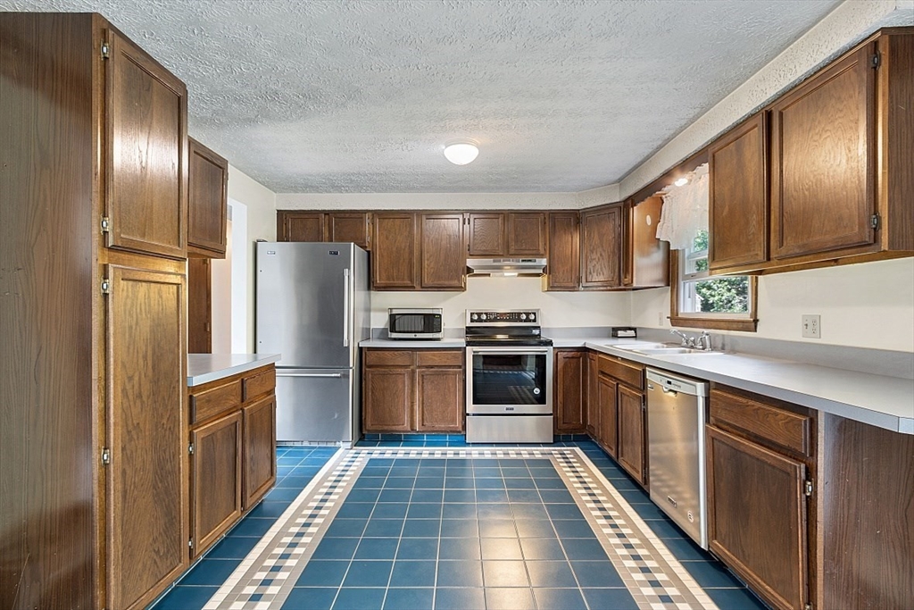 4 Ridgemont Drive Londonderry, NH 03053 - Photo 11 of 33 a kitchen with stainless steel appliances granite countertop a refrigerator stove and sink