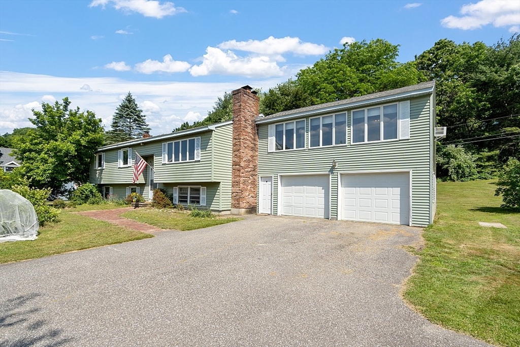 4 Ridgemont Drive Londonderry, NH 03053 - Photo 6 of 33 a front view of a house with a yard and garage