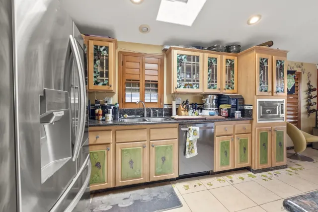 a kitchen with stainless steel appliances granite countertop a stove a sink and a refrigerator