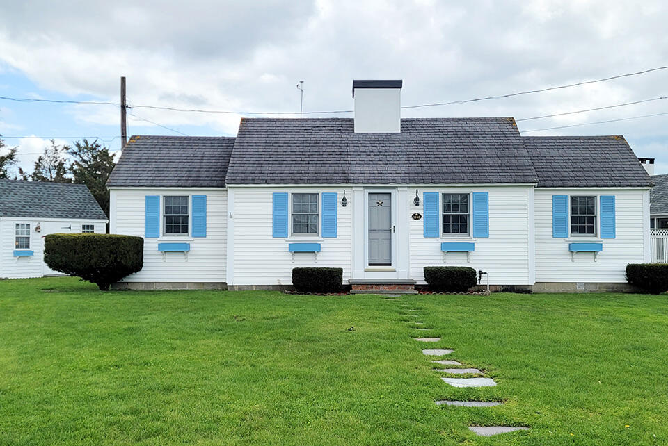 1090 Craigville Beach Road Centerville, MA 02632 - Photo 1 of 33 a front view of a house with a yard and garage