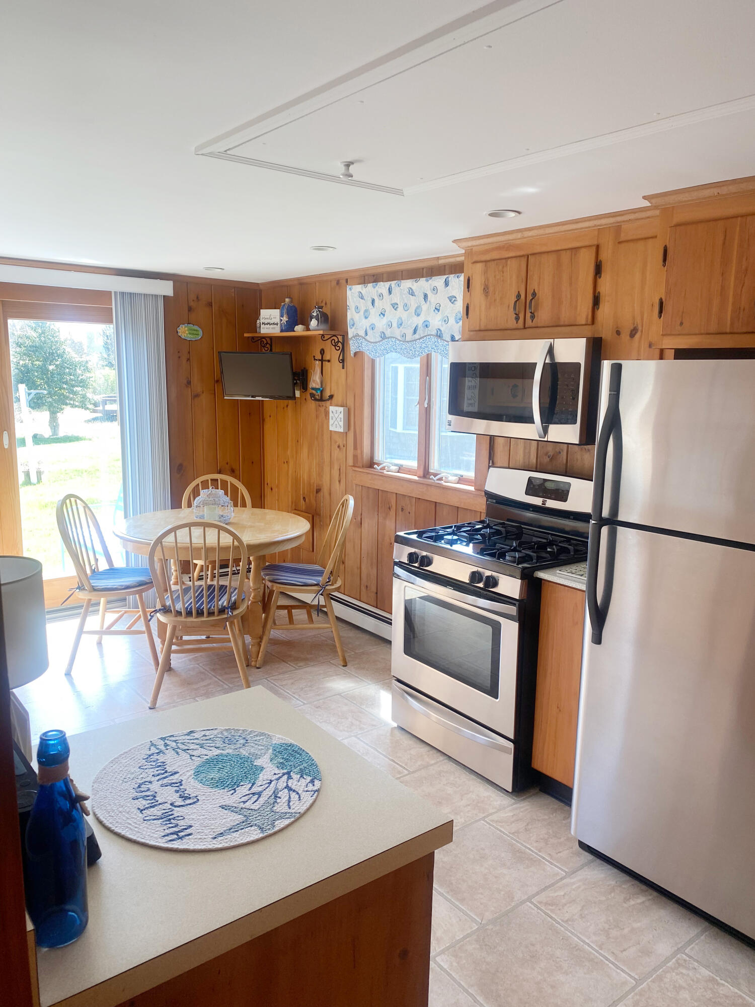 1090 Craigville Beach Road Centerville, MA 02632 - Photo 27 of 33 a kitchen with stainless steel appliances granite countertop a stove refrigerator and a dining table with wooden floor