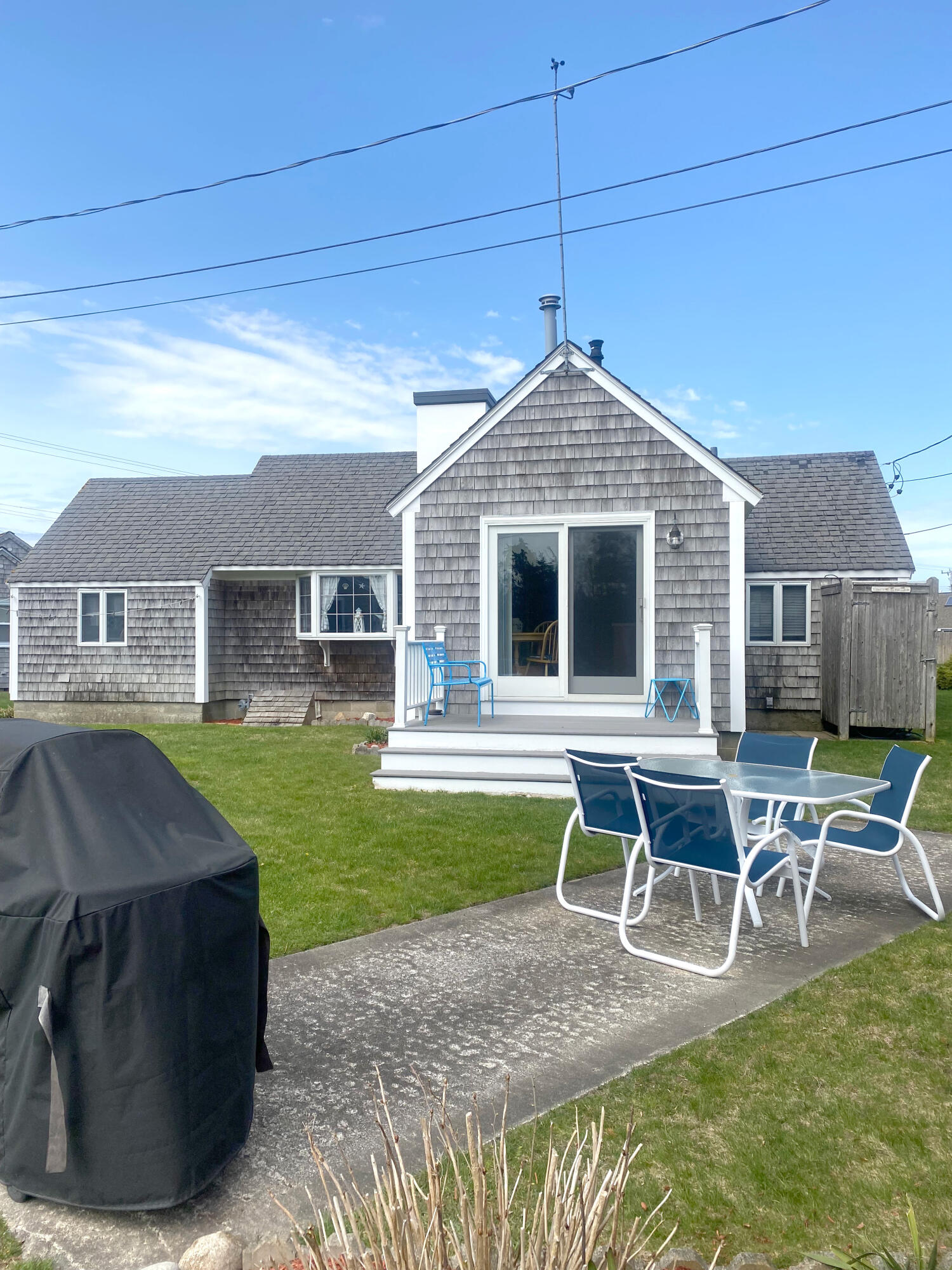 1090 Craigville Beach Road Centerville, MA 02632 - Photo 7 of 33 a front view of a house with a yard porch and outdoor seating