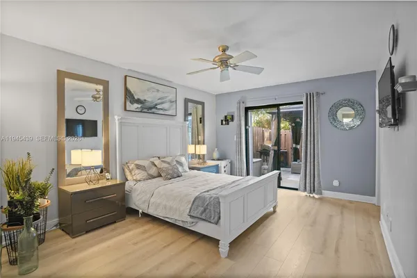 a bedroom with a large bed and potted plants on the dresser
