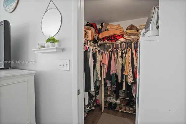 a view of walk in closet with clothes and shoes