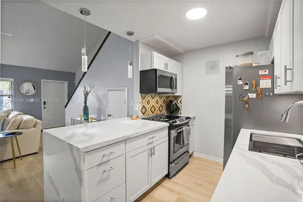 a kitchen that has a sink a stove and a refrigerator