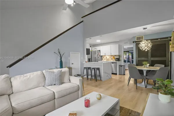 a living room with furniture and a dining table with kitchen view