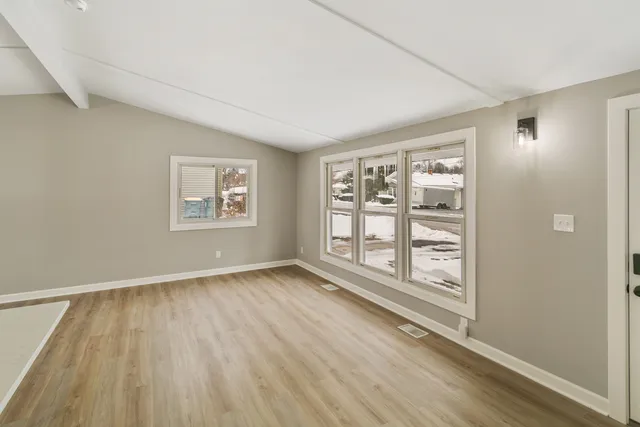 a view of a kitchen with wooden floor electronic appliances and window