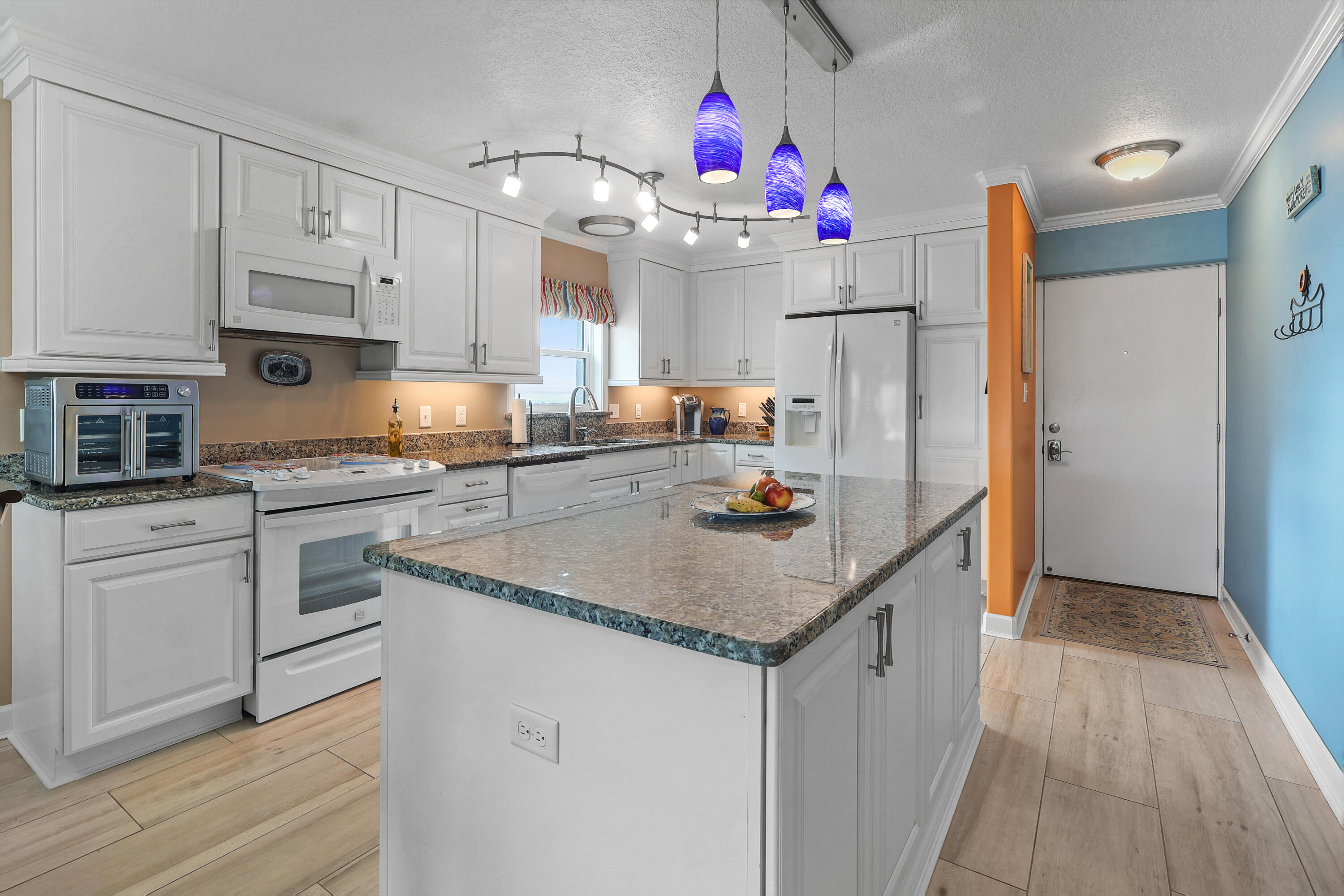 909 Santa Rosa Boulevard, Unit 229 Fort Walton Beach, FL 32548 - Photo 13 of 48 a kitchen with granite countertop a white refrigerator and white cabinets