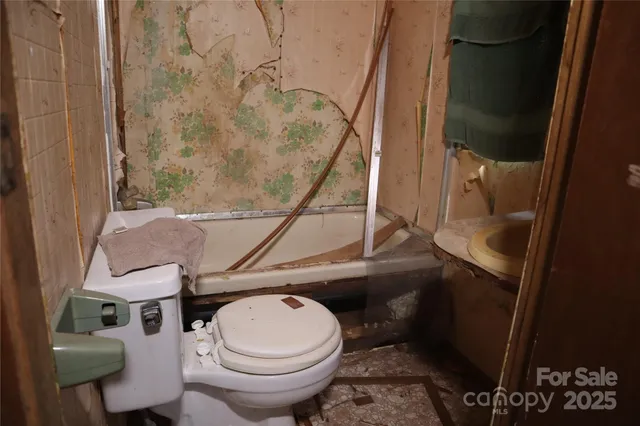 a bathroom with a toilet and a shower
