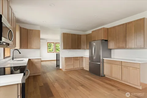 a kitchen with cabinets appliances a sink and a window