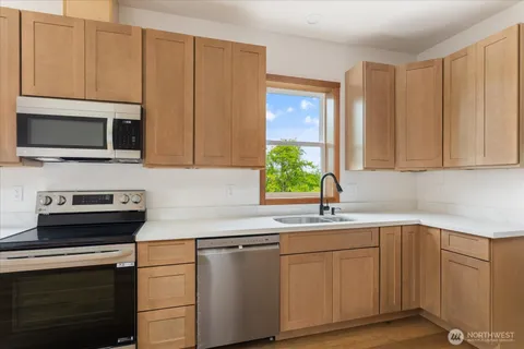 a kitchen with a refrigerator stove top oven and sink