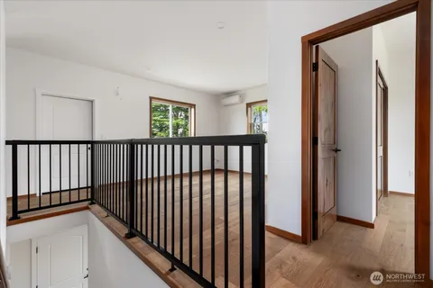 a view of a hallway with wooden floor and entryway