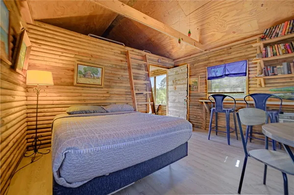 a bedroom with a bed a table and chairs