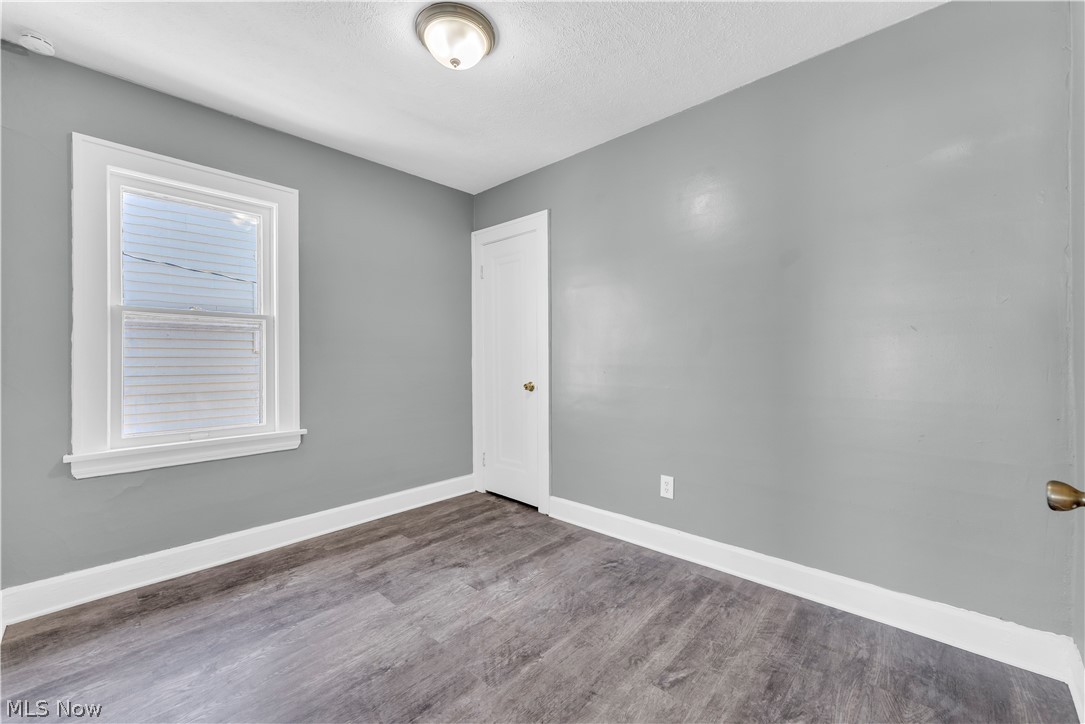12808 Havana Road Cleveland, OH 44125 - Photo 14 of 19 Room featuring wood-finish flooring, light grey walls, white trim, a single window, and a white interior door