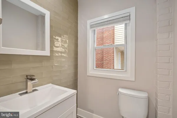 a bathroom with a sink a toilet and a window