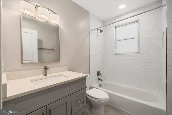 a bathroom with a sink mirror toilet and bathtub